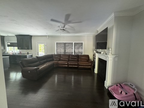 A living room with a brown couch and a fireplace.