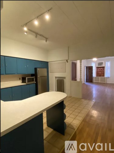 A kitchen with blue cabinets and a white counter.