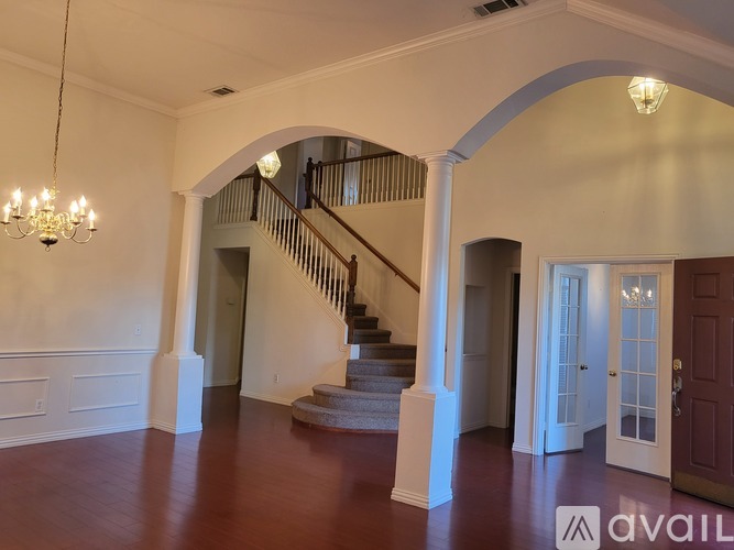 A large open space with a staircase and a chandelier.