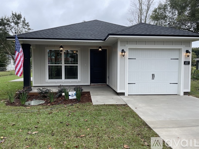 A small house with a garage and an American flag.