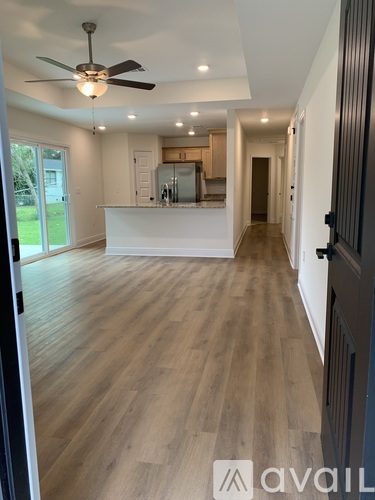 A spacious room with wooden flooring and a ceiling fan.