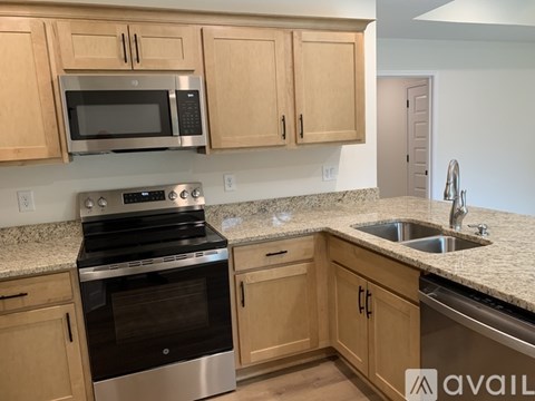 A kitchen with wooden cabinets and granite countertops.