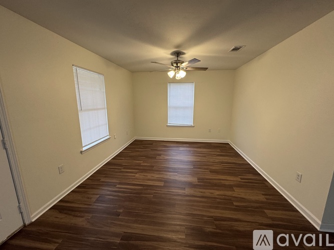 A room with wooden flooring and a ceiling fan.