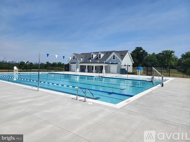 A large outdoor swimming pool with a house in the background.