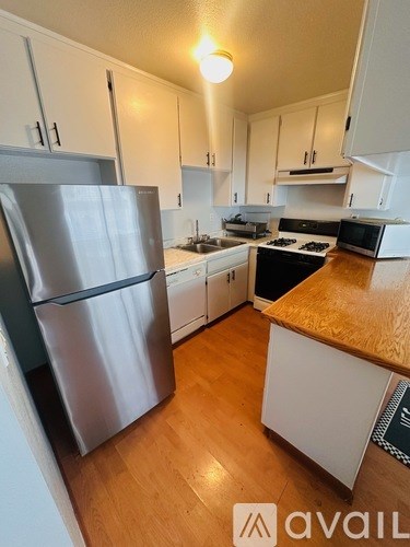A kitchen with a refrigerator, stove, and microwave.