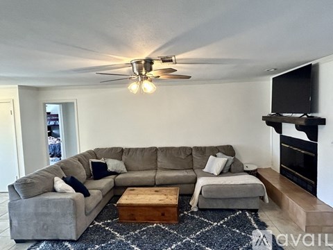 A living room with a grey couch and a wooden coffee table.