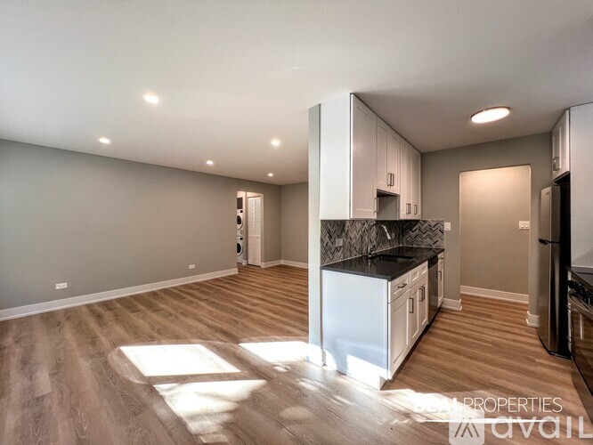 A kitchen with a white fridge and a black countertop is available for rent.