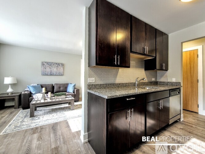 A modern kitchen with dark wood cabinets and a granite countertop.