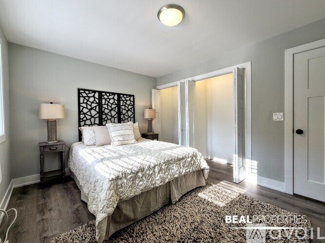 A bedroom with a bed, two lamps, and a patterned headboard.
