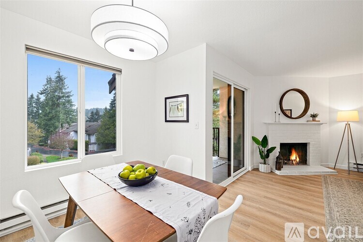A dining room with a table, chairs, and a fireplace.