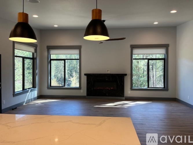 A spacious living room with a fireplace and large windows.