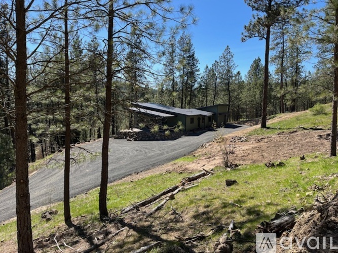 A house is situated on a hill with a road leading up to it.