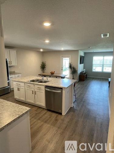 A kitchen with white cabinets and a granite countertop.