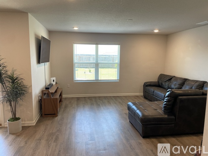 A living room with a brown leather couch and a wooden table.