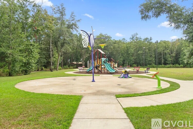 A playground with a slide, swings, and a butterfly sculpture.