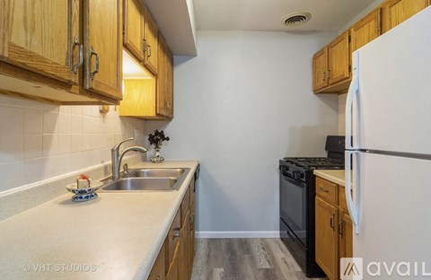 A kitchen with wooden cabinets and a white refrigerator.