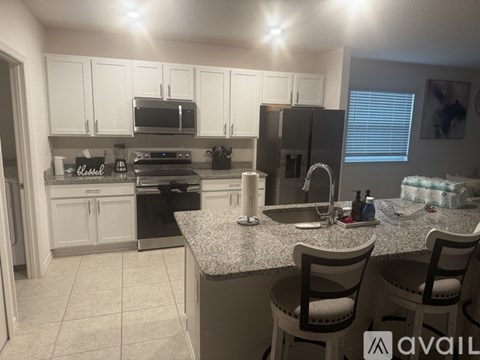 A kitchen with white cabinets and a granite countertop.
