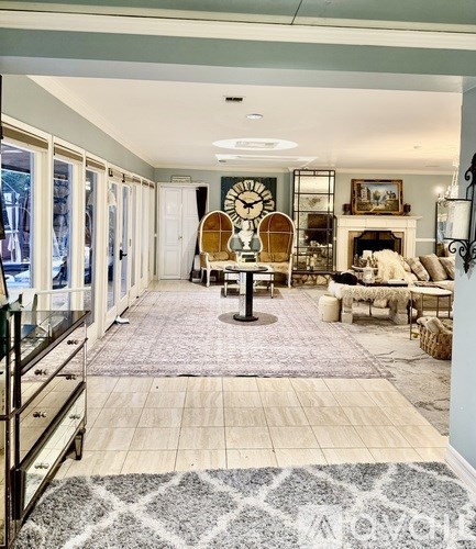 A living room with a large rug and a fireplace.