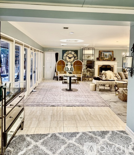 A living room with a large rug and a fireplace.