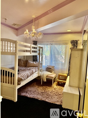 A bedroom with a bunk bed and a chandelier.