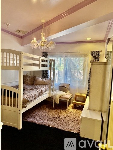 A bedroom with a bunk bed and a chandelier.