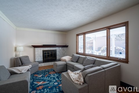 A living room with a grey couch and a fireplace.