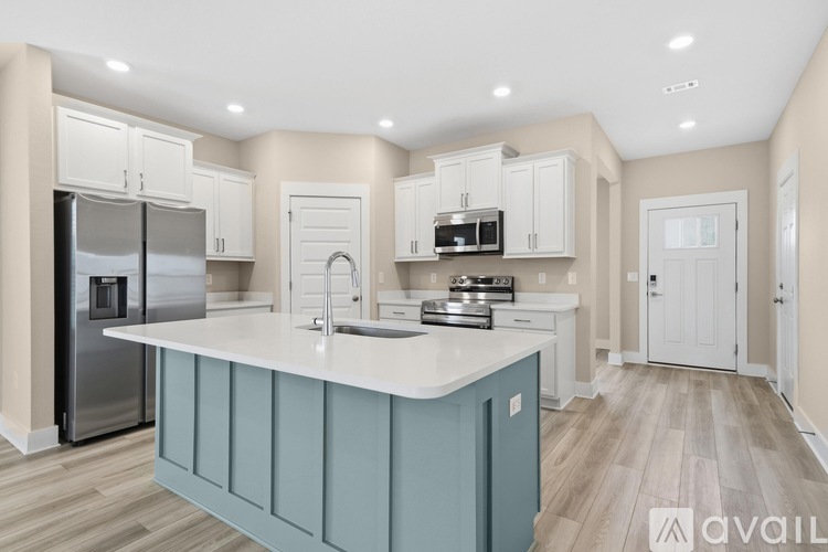 A kitchen with a blue island and white cabinets.