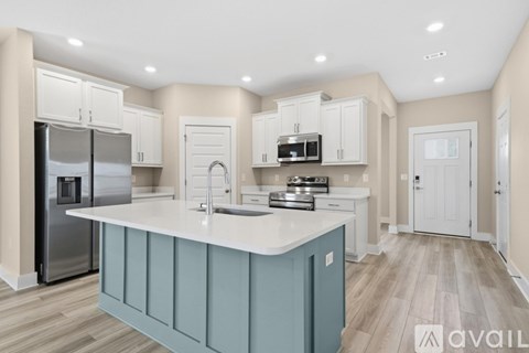 A kitchen with a blue island and white cabinets.