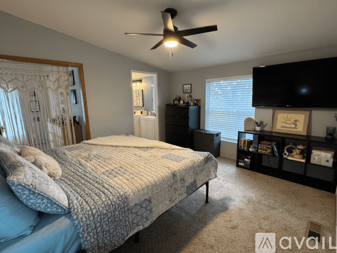A bedroom with a bed, dresser, and ceiling fan.