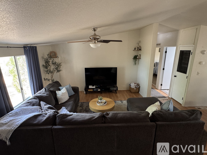 A living room with a dark brown couch and a flat screen TV.