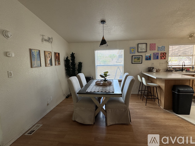 A dining room with a table set for six people.
