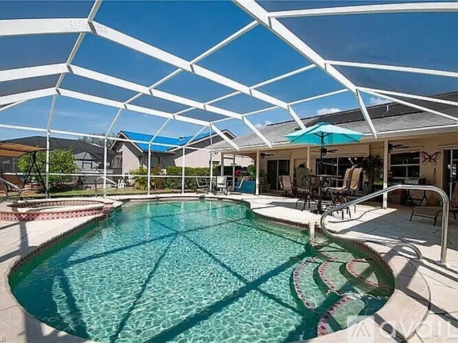 A pool under a white canopy with a blue sky in the background.