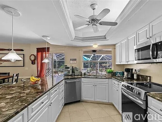 A kitchen with granite countertops and white cabinets.
