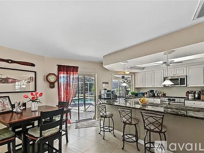 A kitchen with a table and chairs in front of a window.