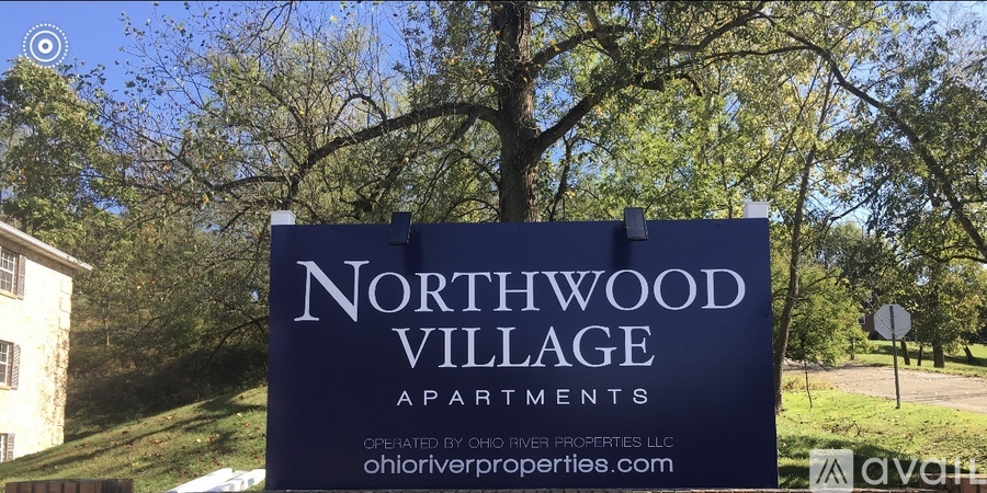 A sign for Northwood Village Apartments sits in front of a building.