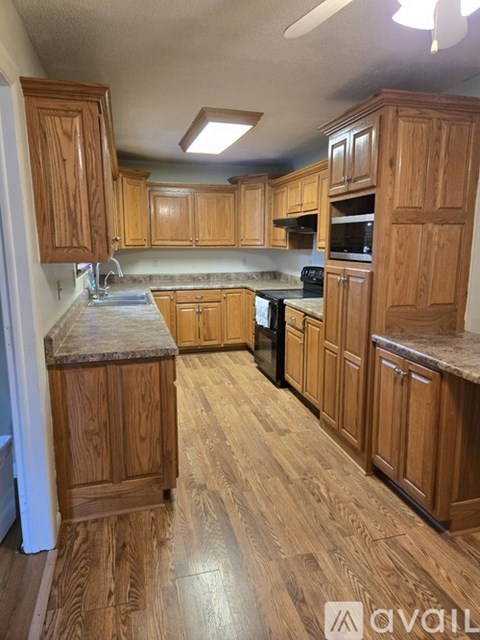A kitchen with wooden cabinets and a marble countertop.