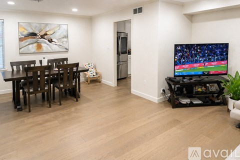 A living room with a television and a dining table.