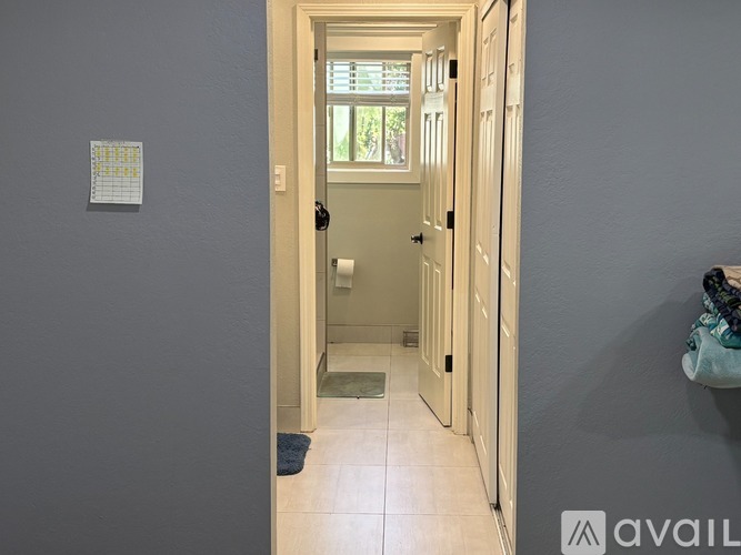A hallway with a door leading to a bathroom.