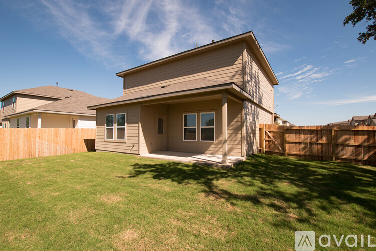 A house with a brown fence and a green lawn.