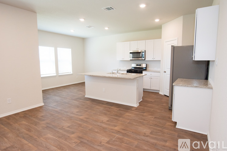 A kitchen with white cabinets and a wooden floor.