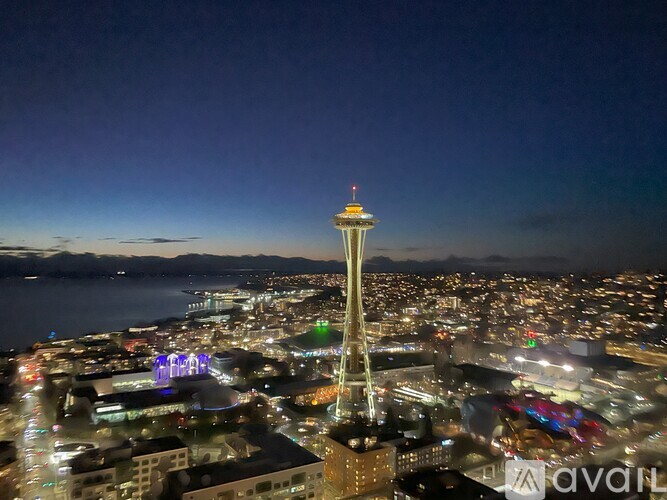 A cityscape at night with a prominent tower in the center.