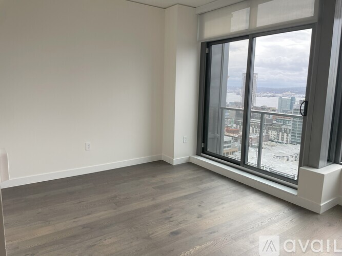 A spacious room with a large window overlooking a cityscape.