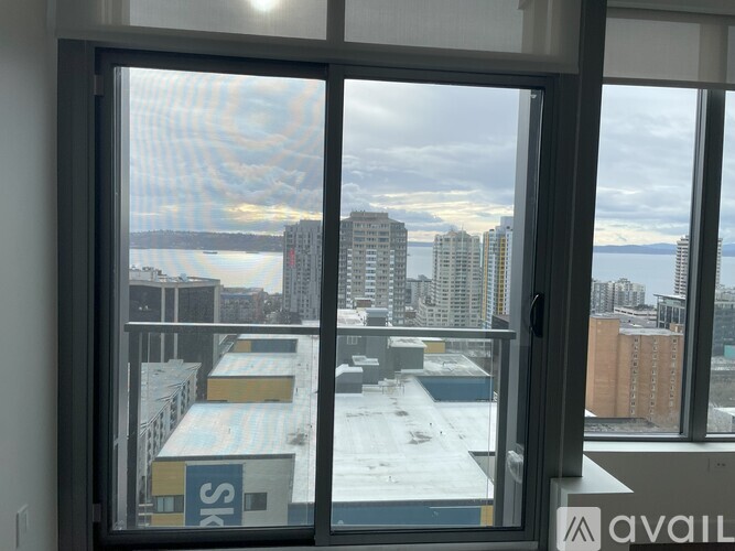 A view from a window looking out at a cityscape with buildings and a body of water.