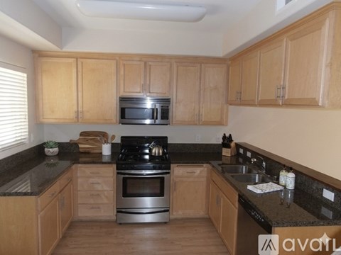 A kitchen with wooden cabinets and a black stove top.