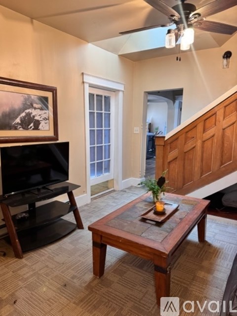 A living room with a wooden coffee table and a flat screen TV.