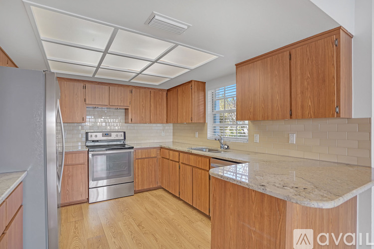 A kitchen with wooden cabinets and a marble countertop.