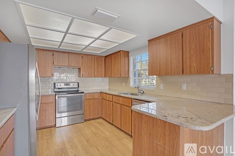 A kitchen with wooden cabinets and a marble countertop.