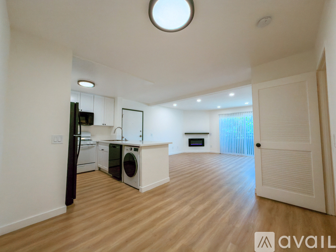 A modern kitchen with a washing machine and a fridge.