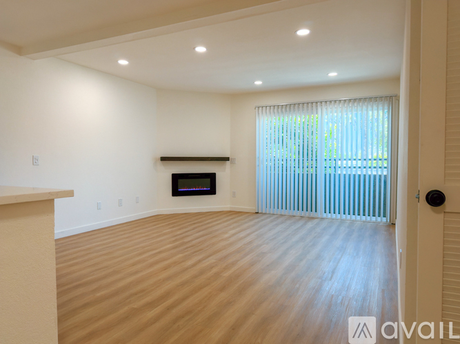 A room with a wooden floor and a fireplace.
