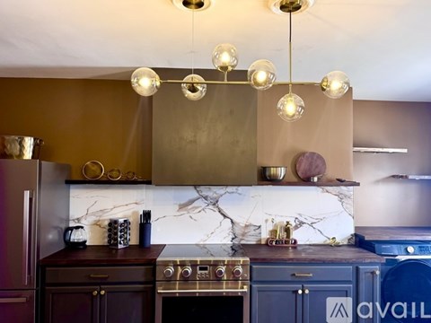 A kitchen with a marble backsplash and a stove top oven.